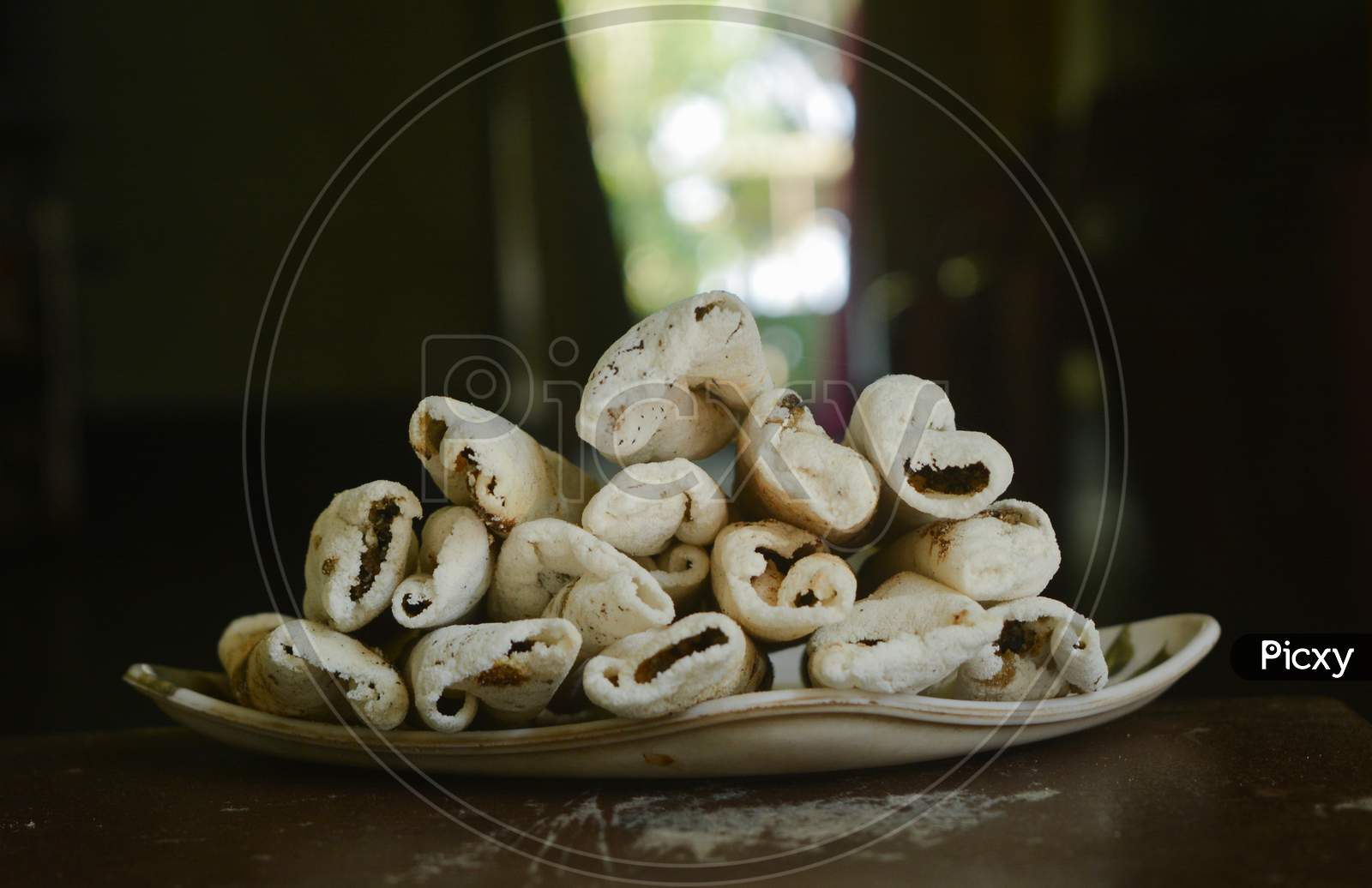 A Traditional food (sweet) of Assam. TIL PITHA, which is made with cocunut or TIL and rice.