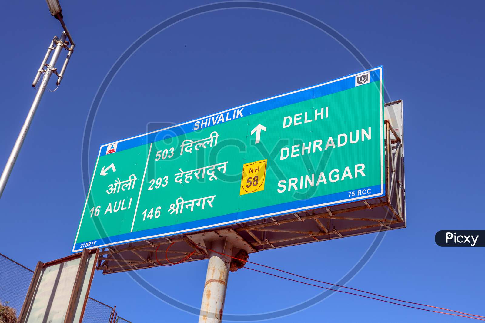 Auli ,Uttarakhand /India-March 16,2020: Road Direction Sign Board At Delhi -Uttarakhand Highways Roads Written In English  And Hindi Language  Near  Lamp Post