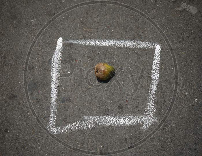 A dried up coconut is left to secure a spot in a box drawn on a street to maintain social distancing during the nationwide lockdown to stop the spread of Coronavirus (COVID-19) in Bangalore, India, May 02, 2020.