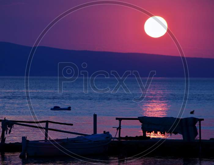Late evening sunset scenery with lonely boat in Kampor bay, island Rab, Croatia