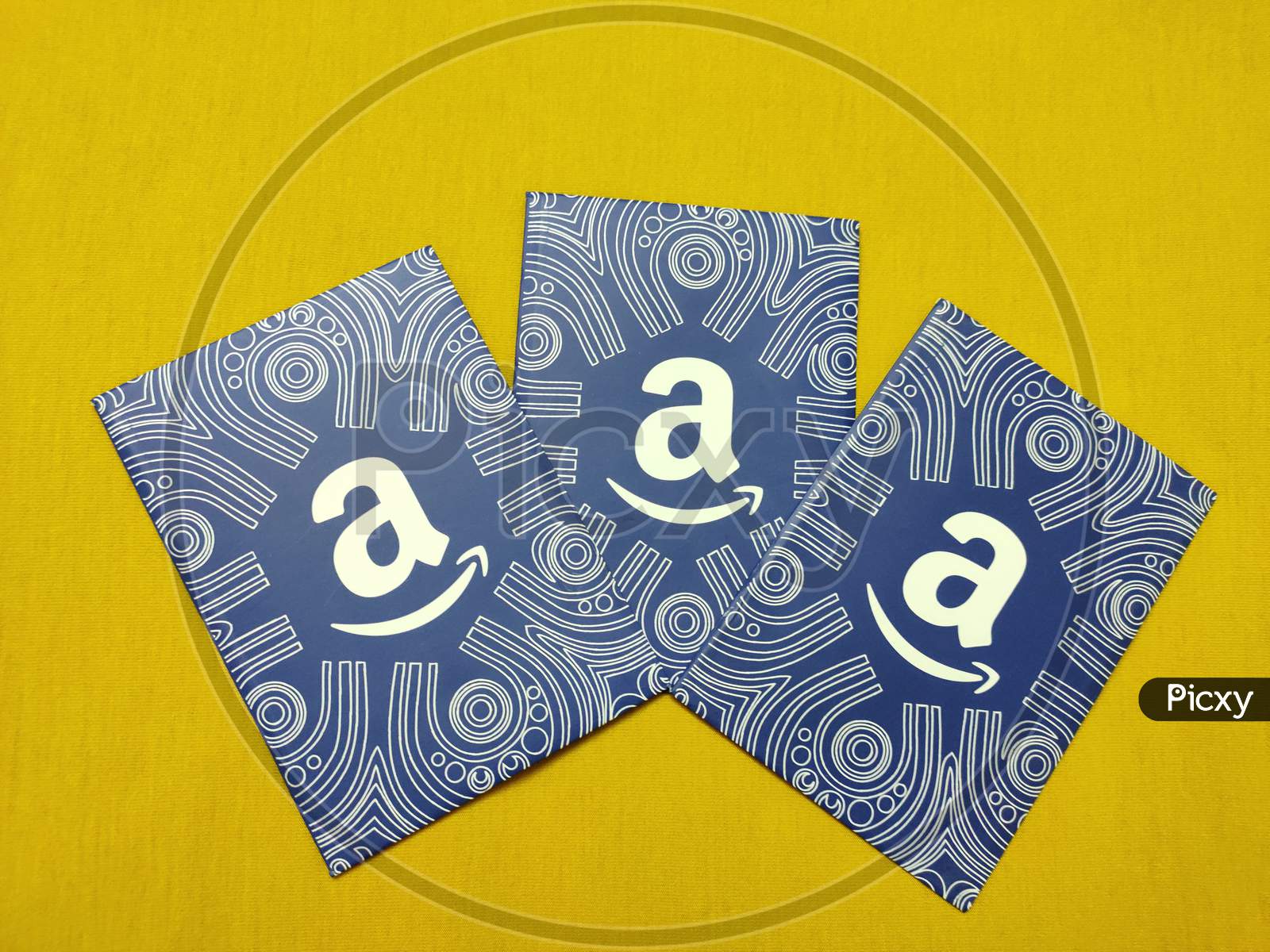 Noida, UP / India - Aug 31, 2019: Amazon gift cards isolated on yellow background with space for text, which allows the recipient to purchase items from the Amazon.com website