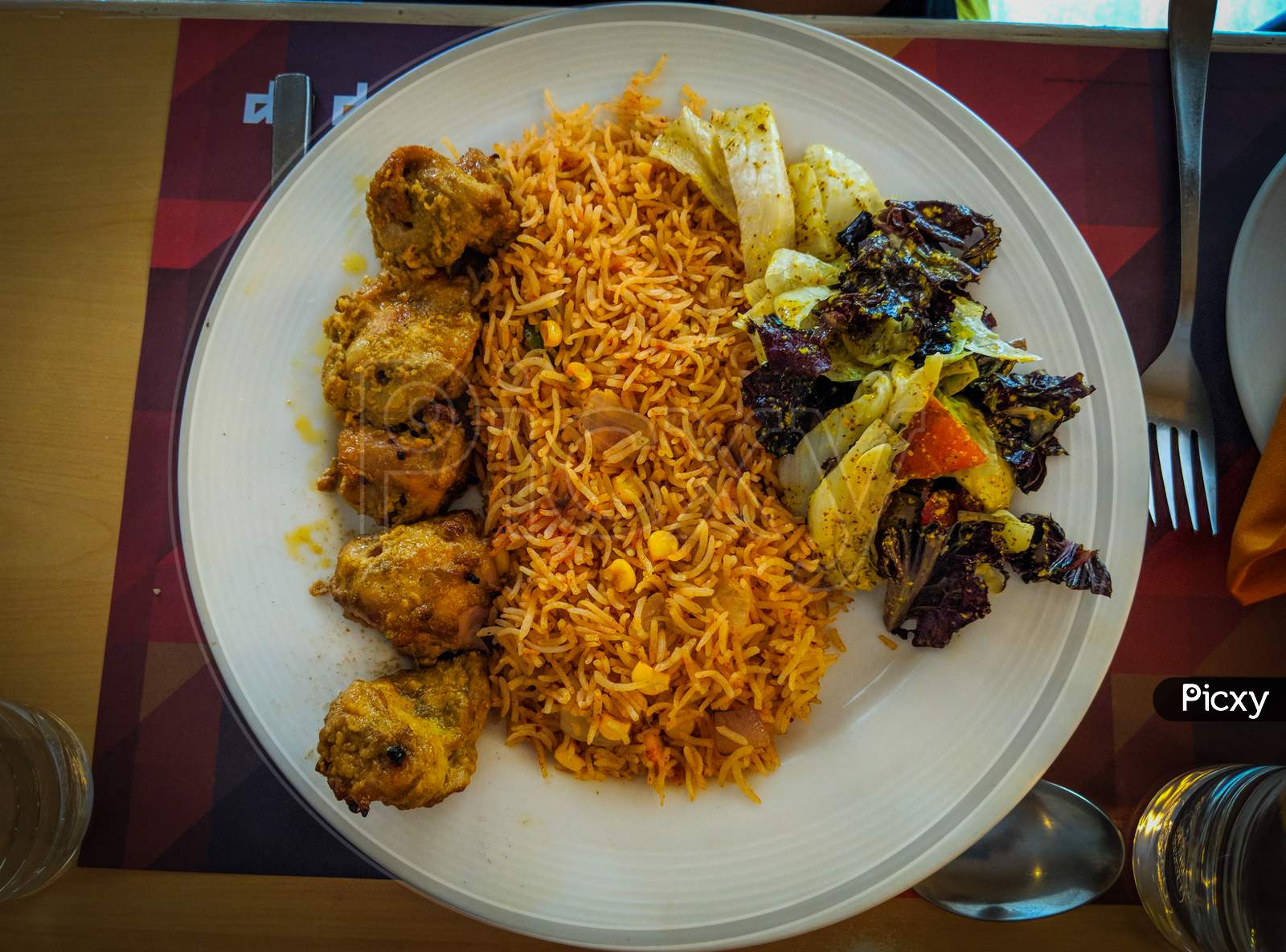 Tandoori kebab chicken with schezwan corn rice, A continental dish served on white plate with well garnish