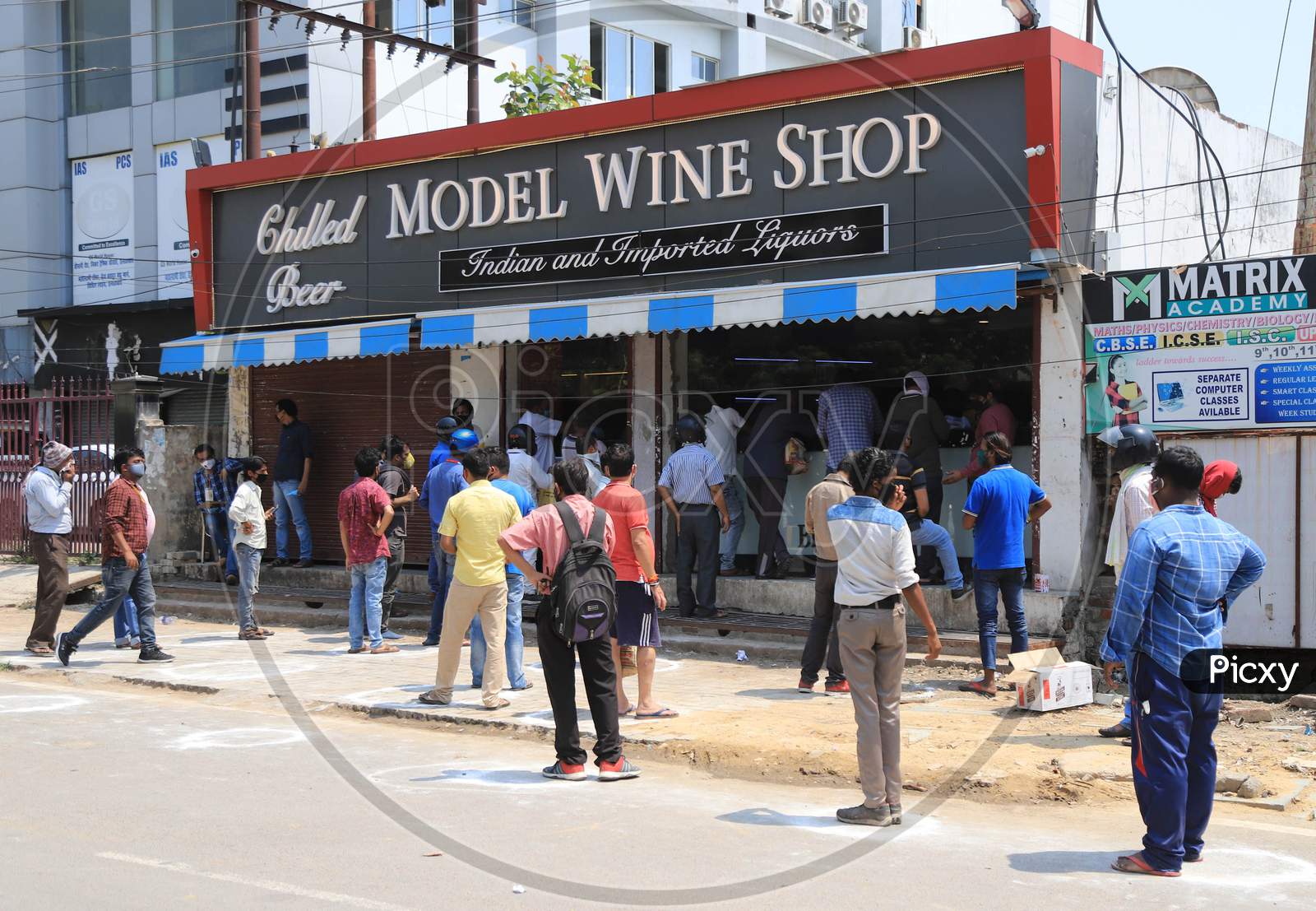 People stand in a queue to buy liquor outside a wine shop during an extended nationwide lockdown to slow the spread of the Coronavirus disease or COVID-19, in Prayagraj on May 4, 2020.
