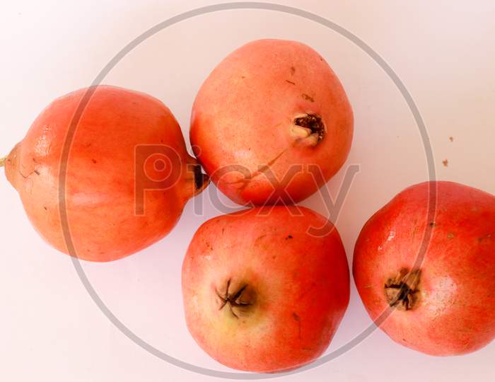 Red pomegranate fruit on pastel pink background. Minimal flat lay concept.