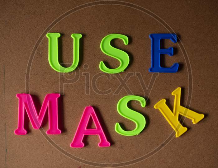 'USE MASK' written on a brown wooden background