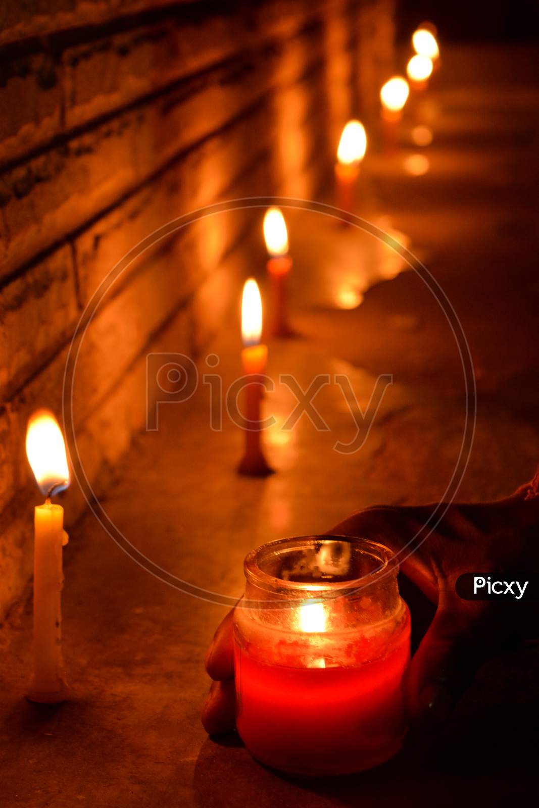 Some candle being lit up in dark night during the Diwali season with feeling of peace, love, faith, truthfulness and home coming. Deep utsav in India during COVID-19 Pandemic.