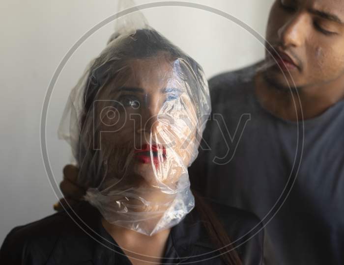 An young Indian man trying to kill his girlfriend by suffocation inside a room. Crime and domestic violence.