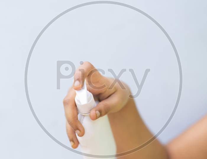 Child'S Hand With Disinfectant Hand Sanitizer Against Plain Background
