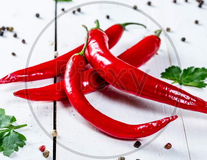 Close-Up Of Red Chili Peppers Against White Background Long Red March Inspirational Scene