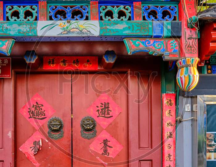 Old Door In A Traditional Beijing Hutong Alley, Decorated With Chinese Characters Symbolizing Good Luck