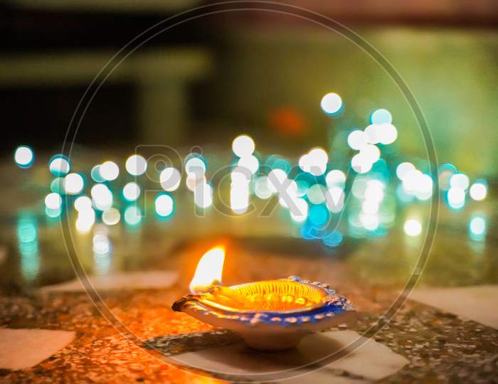 Happy Diwali - Lit diya lamp on street at night