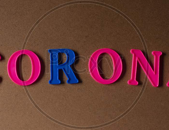 'Corona' written on a brown wooden background