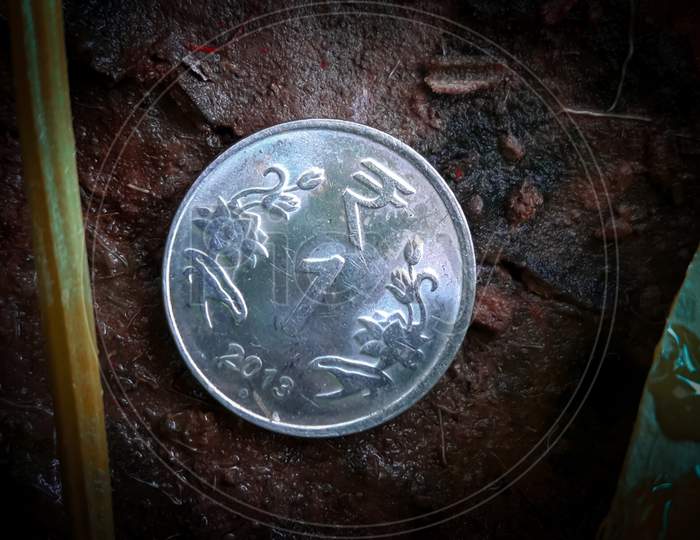 1 Rupee Coin In The Soil With Dust Around It