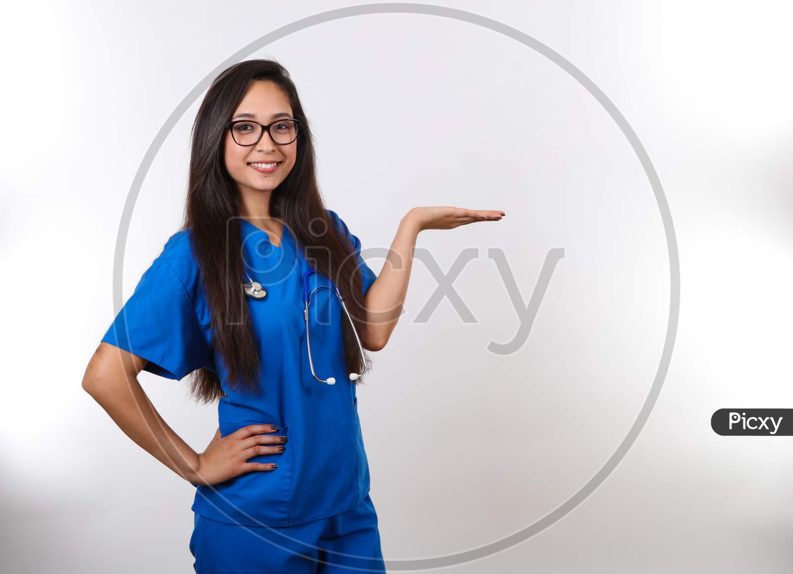 A Young Hispanic Nurse Wearing Glasses Is Holding Her Hand Up.