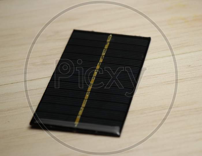 Small Solar Panel Used For Charging Equipments On Wooden Background