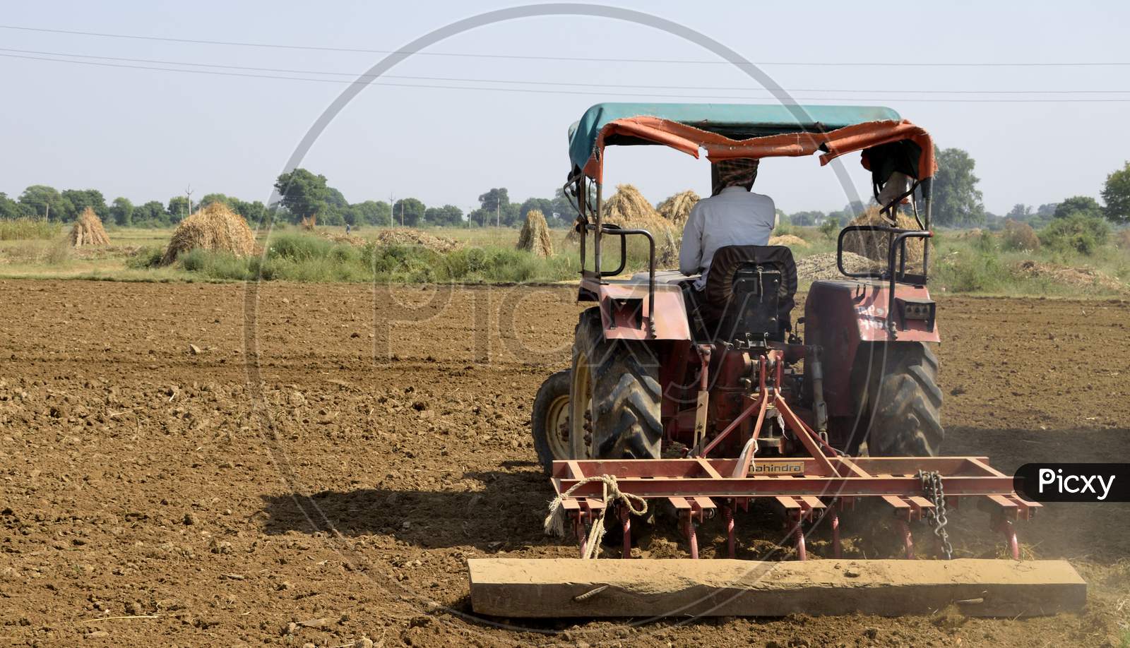 Gwalior, India, October 2018 : An Indian Farmer Is Cultivating A Field With His Tractor, Making It Ready To Sow The Seeds