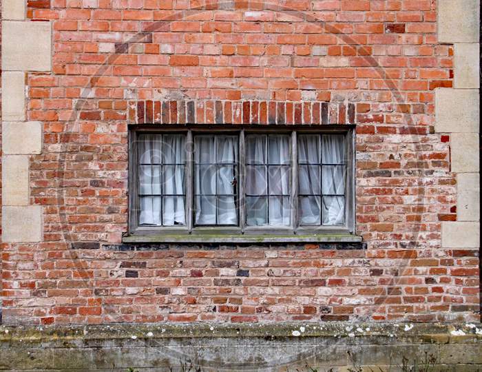 Old Wooden Window In A Weathered Brick Wall In An Old Manor House