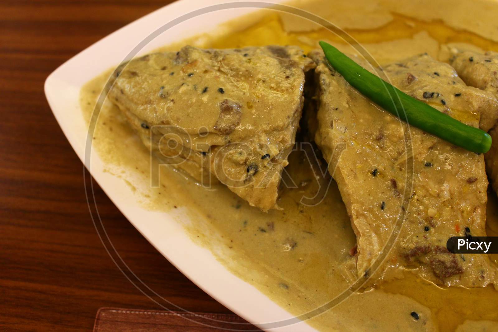 Cooked Hilsa fish and steamed rice served in a restaurant
