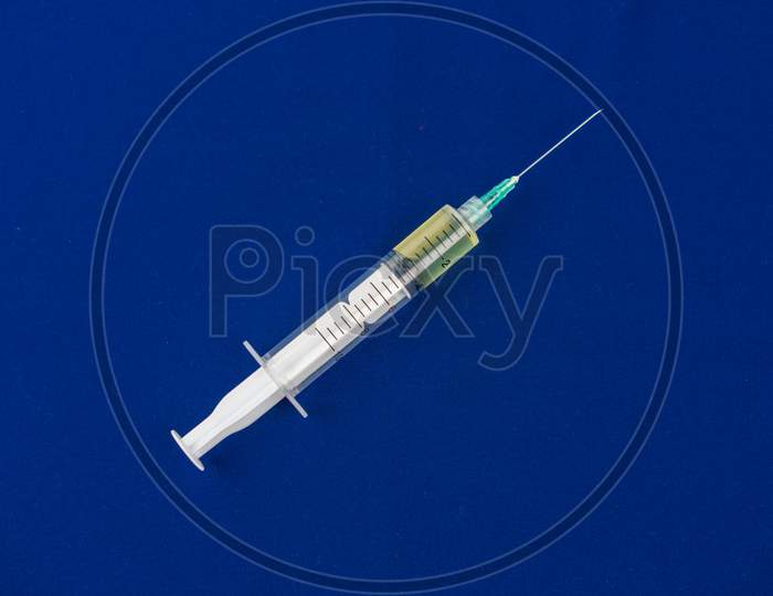 Syringe Closeup Isolated On Blue Background