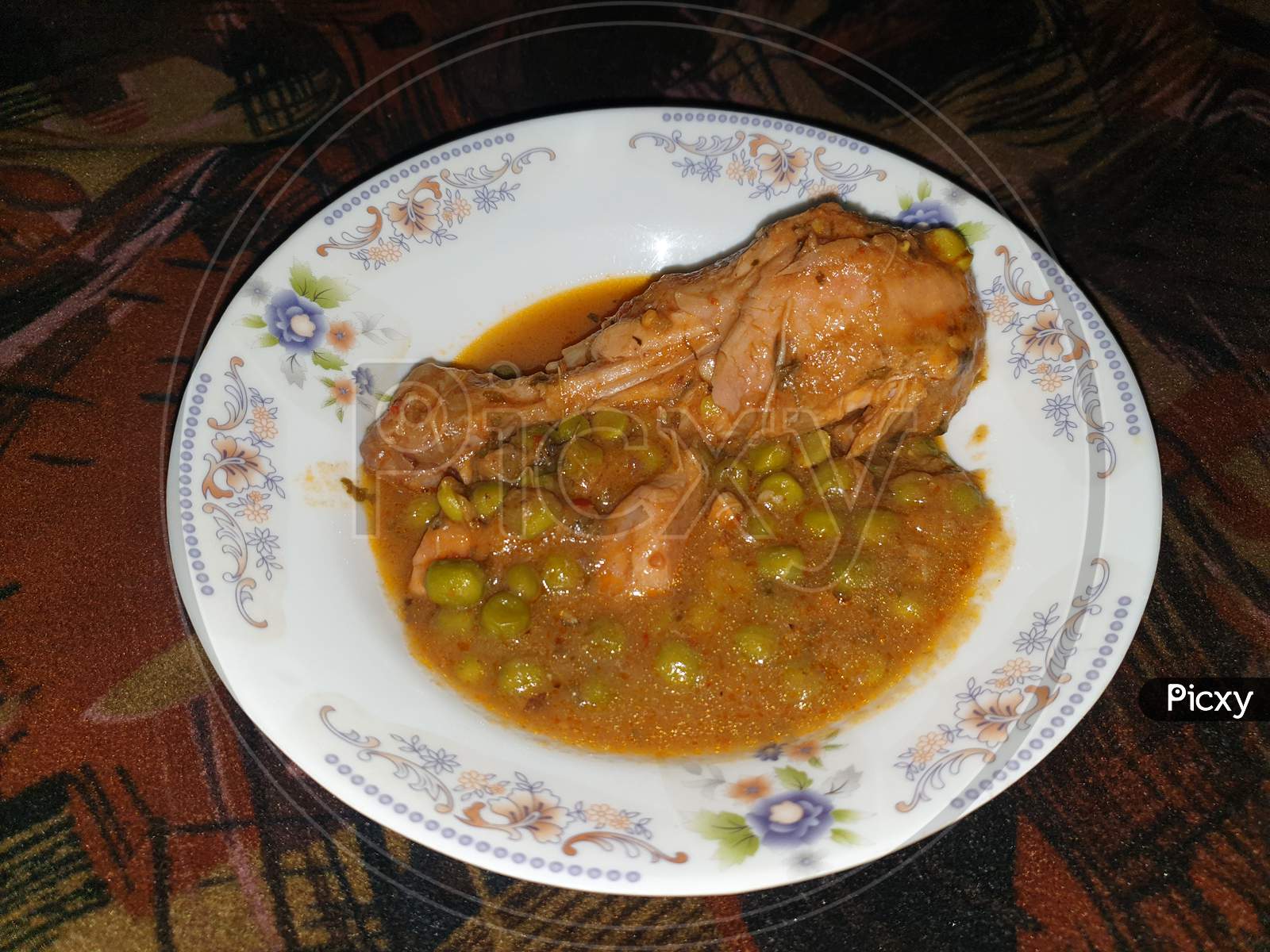 homemade Pakistani chicken curry with pea in traditional plate