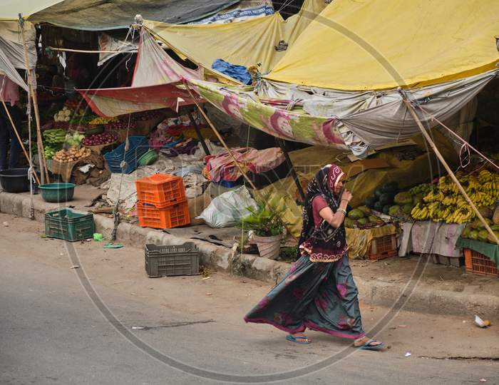 Indian Woman Walking Past A Fruit And Vegetable Street Market In Jaipur, Rajasthan, India