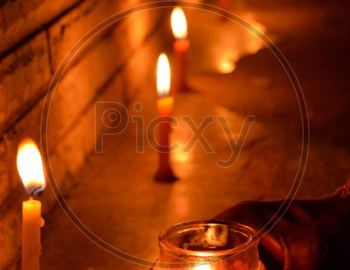 Some candle being lit up in dark night during the Diwali season with feeling of peace, love, faith, truthfulness and home coming. Deep utsav in India during COVID-19 Pandemic.