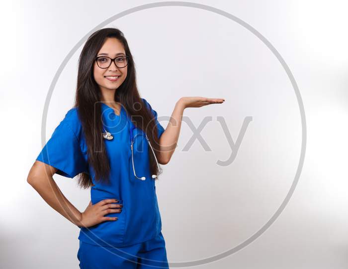 A Young Hispanic Nurse Wearing Glasses Is Holding Her Hand Up.