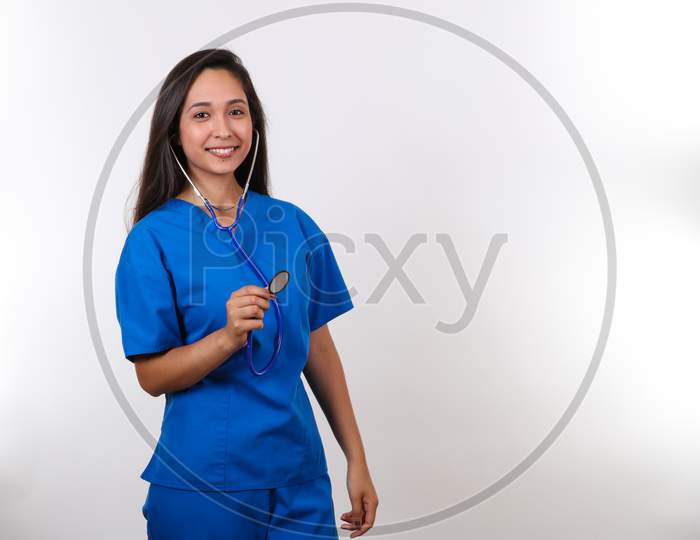 A Young Female Nurse Stands Ready To Check Your Heart With Her Stethoscope.