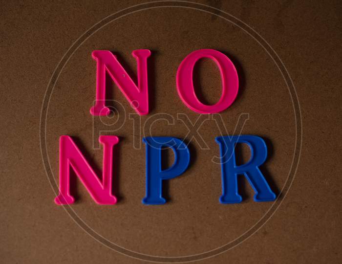'NO NPR' written on a brown wooden background.