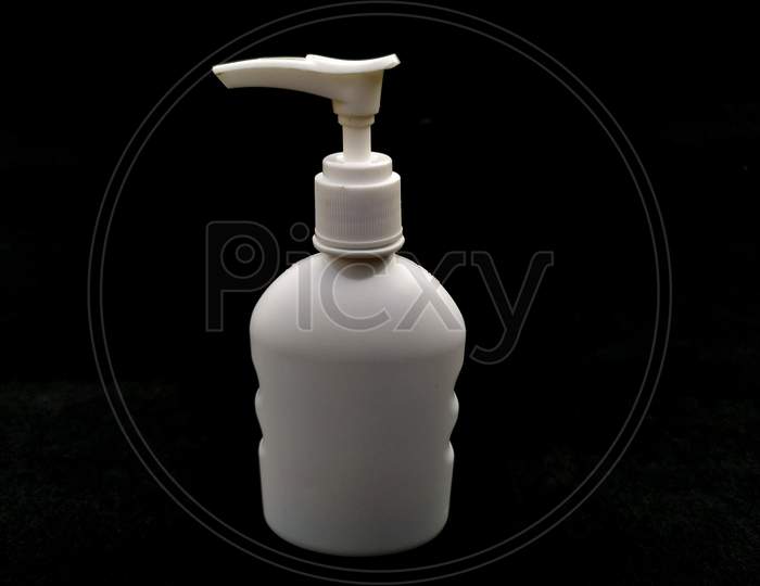 white plastic hand sanitizer bottle isolated on black background