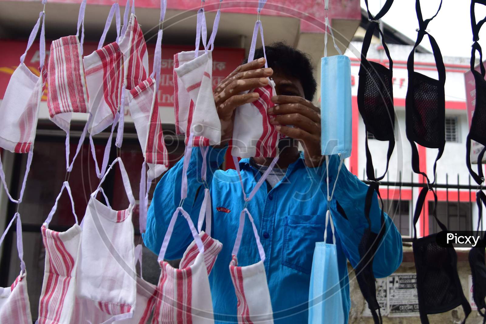 A Man Selling Masks Made From Assamese Traditional Gamosa On His Roadside Shop During Nationwide Lockdown Amidst Coronavirus Or COVID-19 Pandemic  In Nagaon District Of Assam On  May 5, 2020