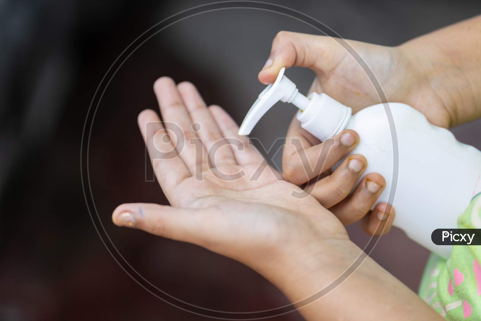 Child'S Hand Holding Sanitizer Bottle
