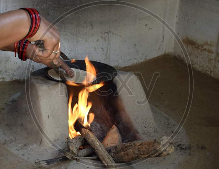 A Rural Indian Woman Preparing Chapati In Traditional Way On A Wood Fired Oven