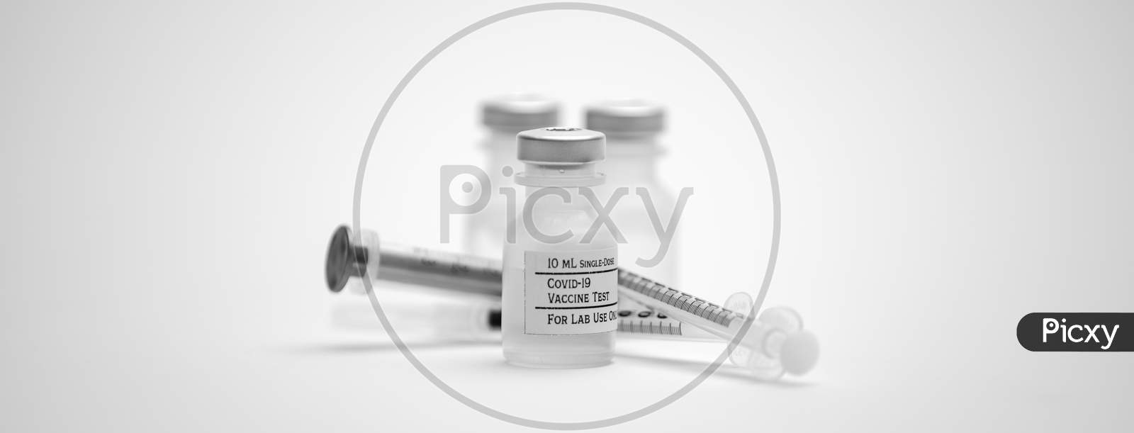Three Covid-19 Test Vaccine Vials And Three Syringes Isolated On A White Background.