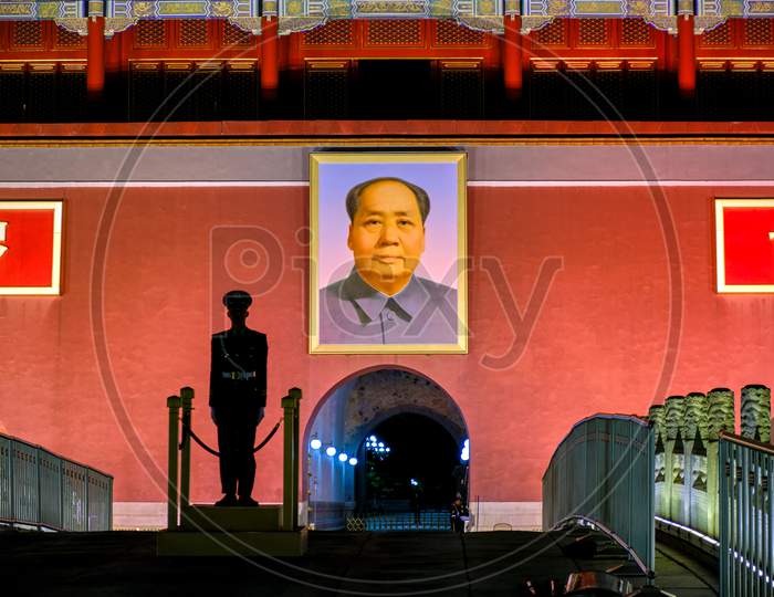 Silhouette Of A Chinese Soldier Standing Guard In Front Of The Portrait Of Mao Zedong At Tiananmen Square In Beijing, China