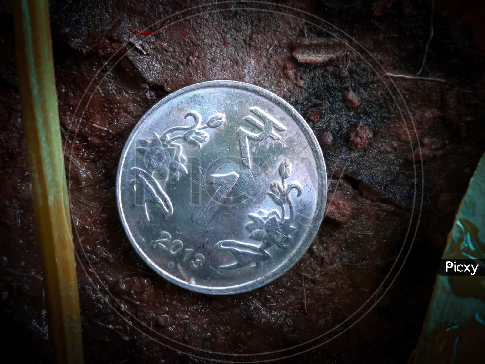 1 Rupee Coin In The Soil With Dust Around It