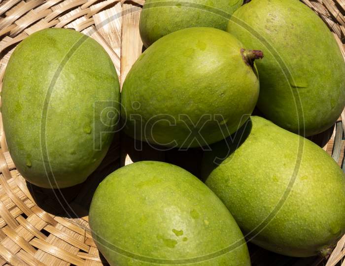 green mangoes in bamboo basket