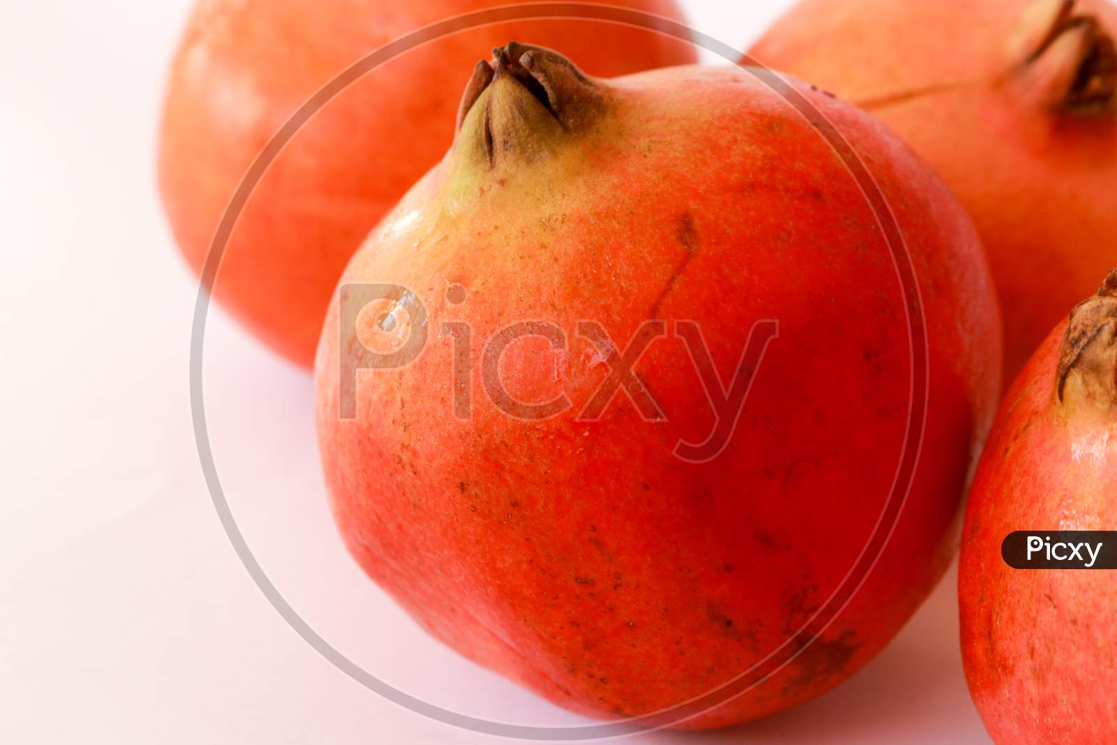 Red pomegranate fruit on pastel pink background. Minimal flat lay concept.