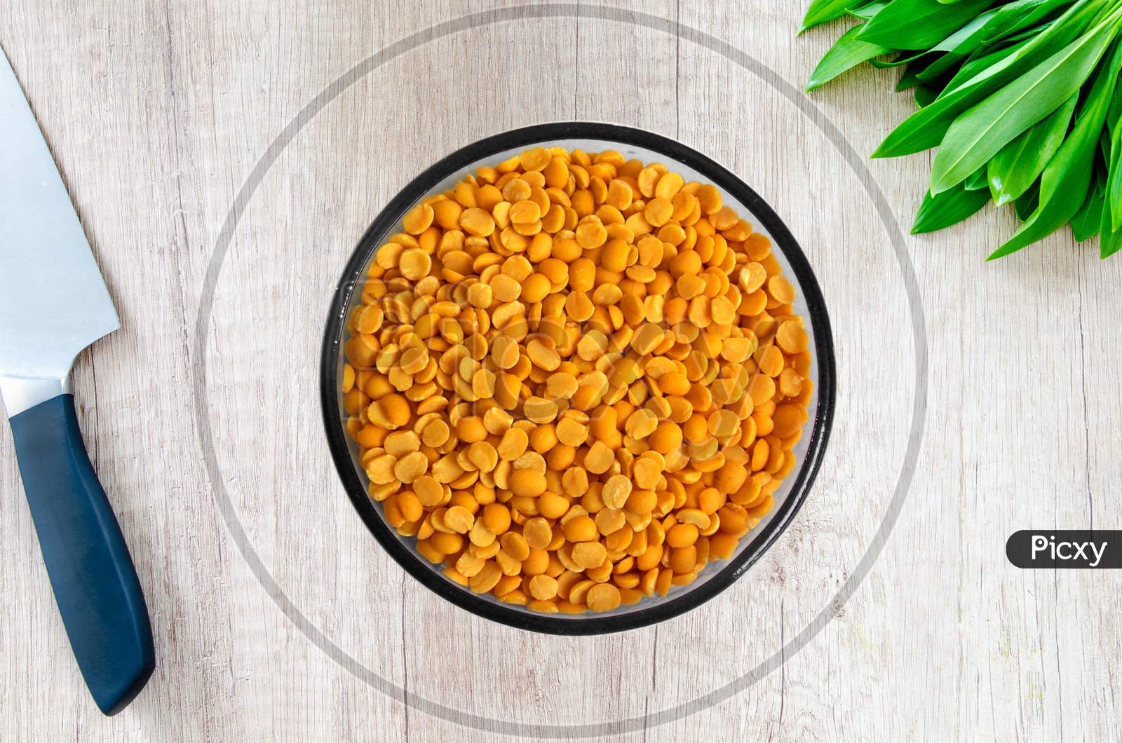 Yellow chopped peas in a bowal on wooden background.Yellow split chickpea peas boot chana dal lentil pulse bean on wooden background,top view.healthy food.