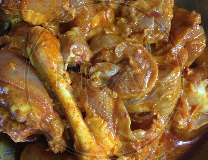 Chicken is being marinated before cooking ,close view