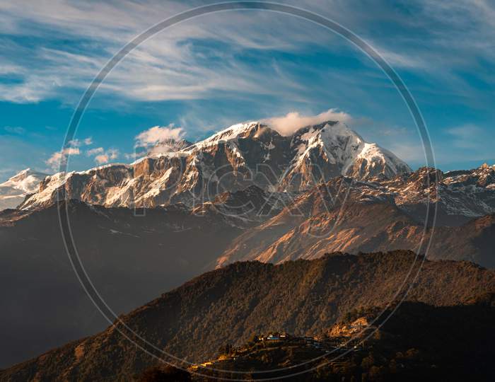 Peaks of mountain in Himalayas and a village below