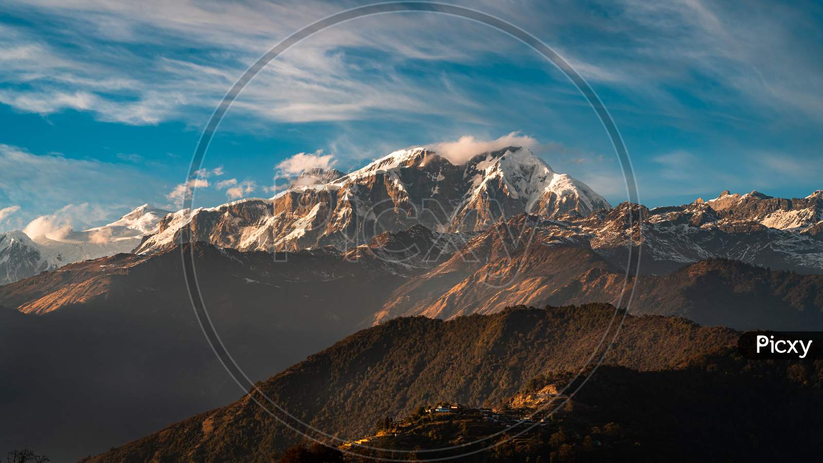 Peaks of mountain in Himalayas and a village below