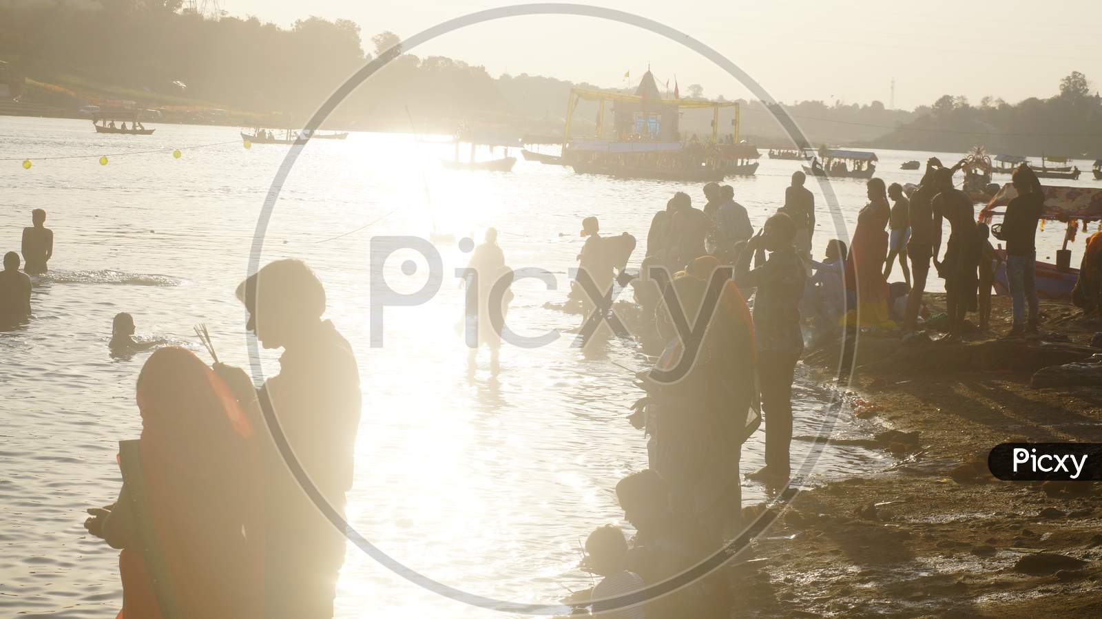 Backlight Image of People offering Prayer in Narmada River