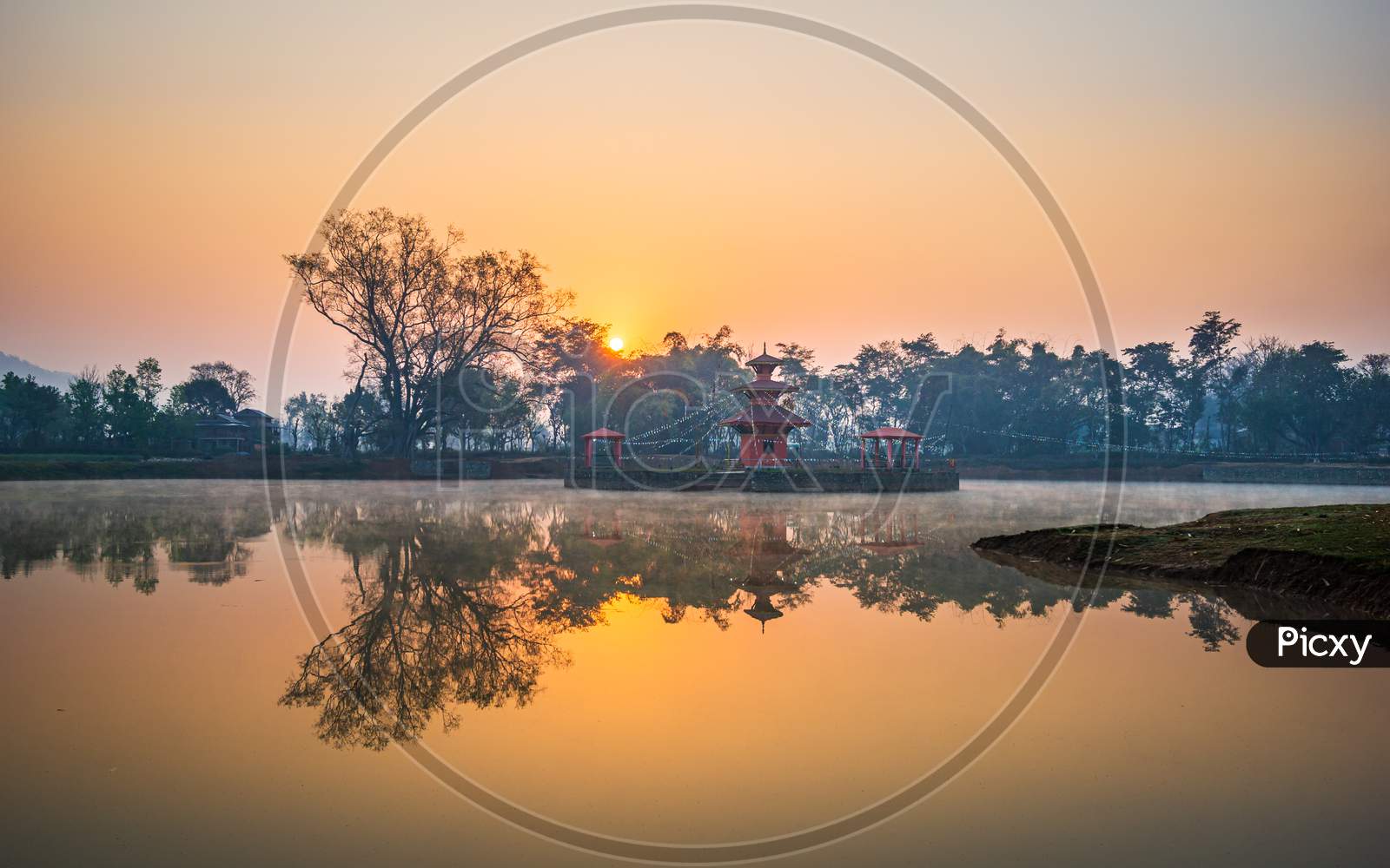 Sunrise behind a temple in the middle of a lake