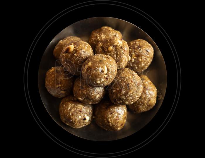 Front view of groundnut laddus A delicious and soft laddu made of groundnut & jaggery mixture homemade peanut laddu tasty & healthy for families dark background