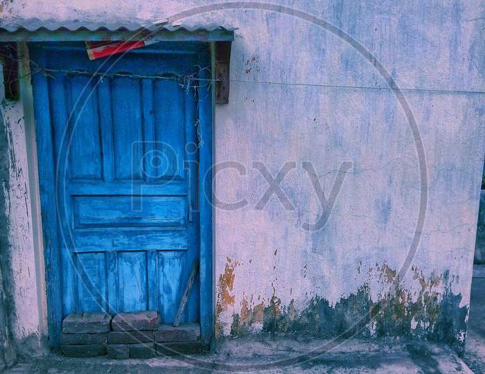 Blue colour old door with tin shade wall side