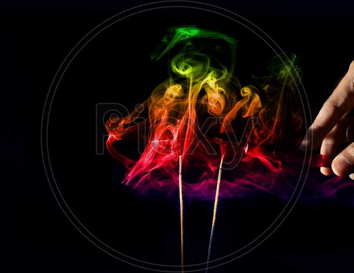 Creative Abstract Smoke Photography With Color Gradient From Incense Sticks With Black Background.