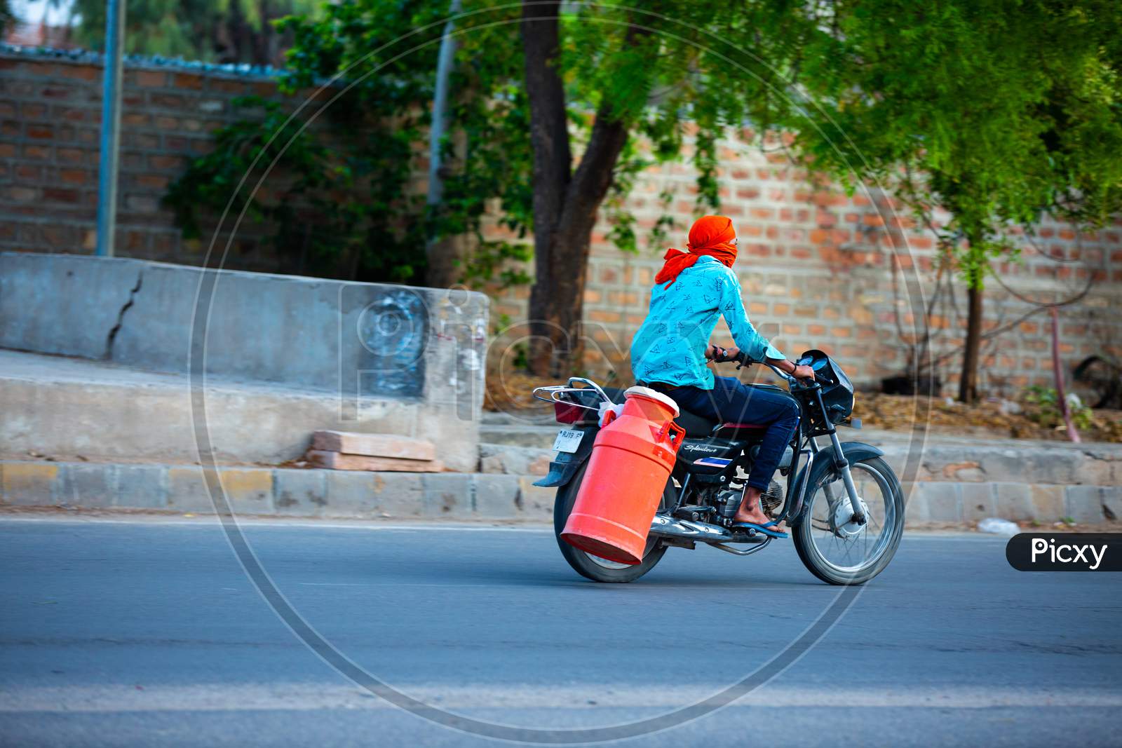 Jodhpur, Rajashtbn, India. 30 March 2020. Man Riding Bike To Sell Milk To The Customers, Coronavirus, Covid-19 Outbreak In India. Lockdown / Curfew In The Country.