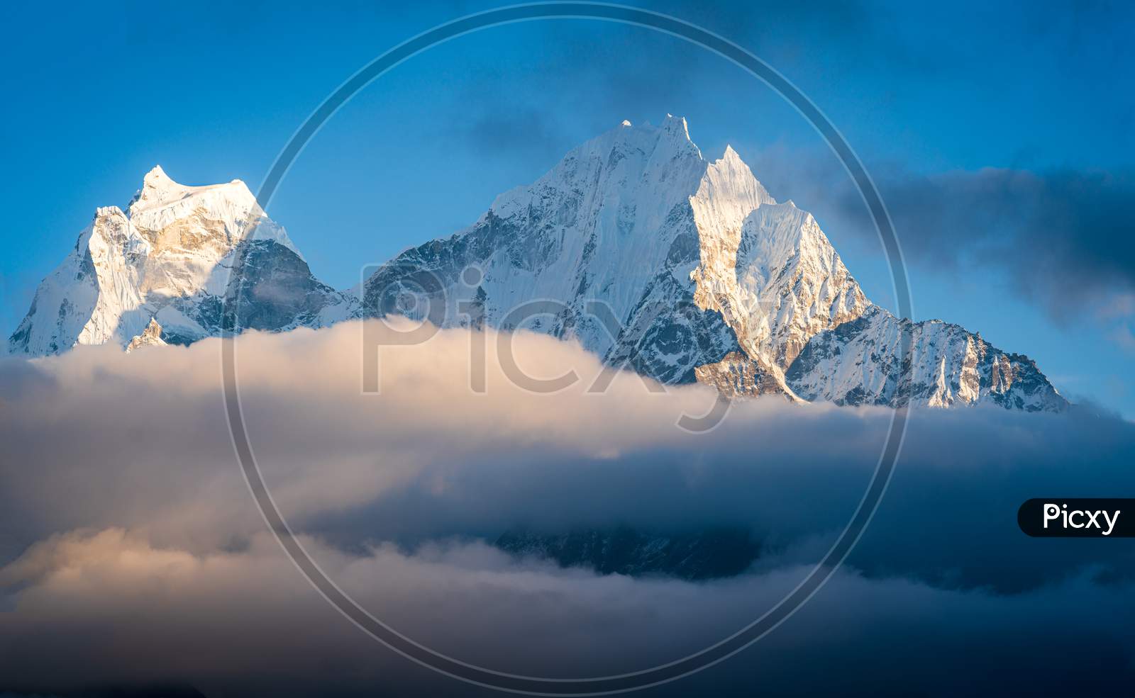 Thamserku and Kangtega mountain peaks towering above cloud