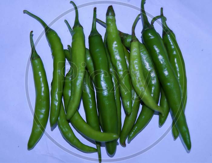 green chilies on a white background